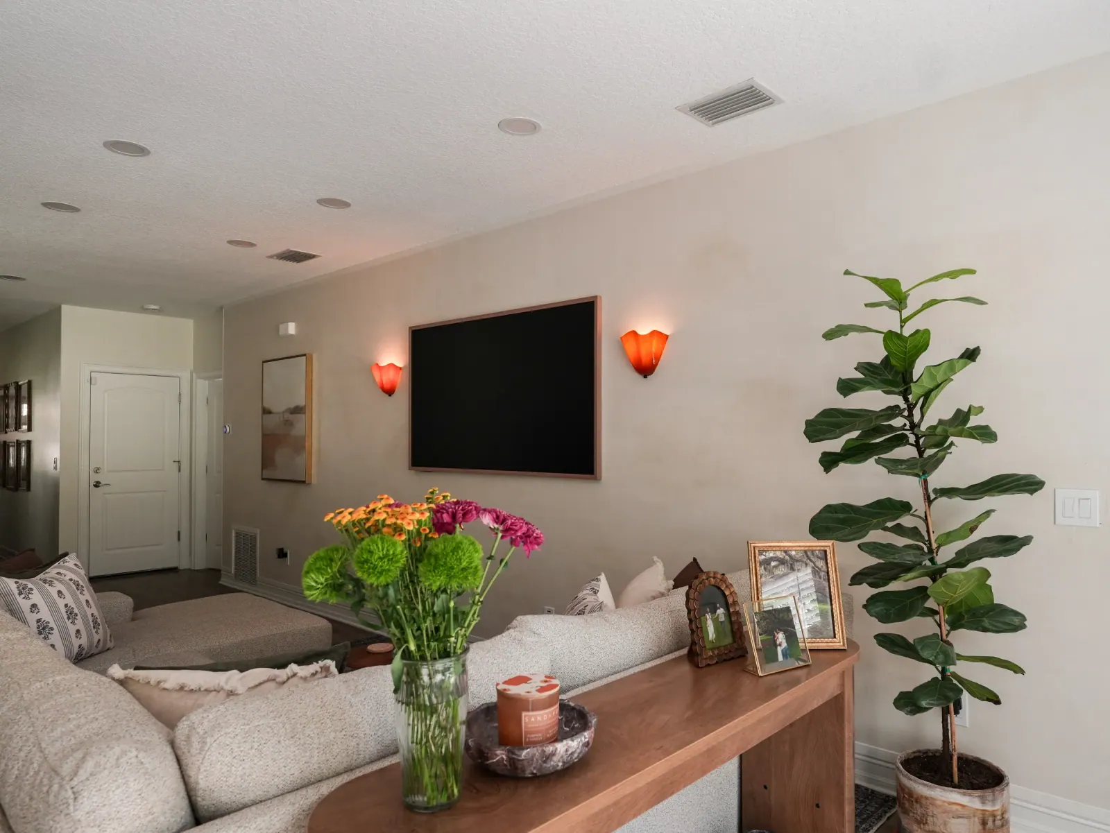 Limewash living room with a media wall and sconces